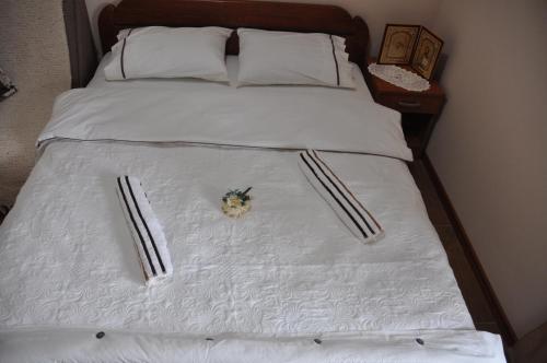 a bed with white sheets and a flower on it at Ostroške grede in Nikšić