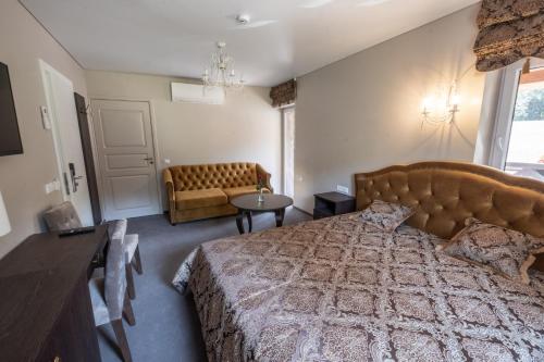 a bedroom with a large bed and a couch at Vila Misko Natos in Dovainonys III