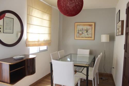 a dining room with a glass table and white chairs at Dream Flat in Santa Cruz de Tenerife