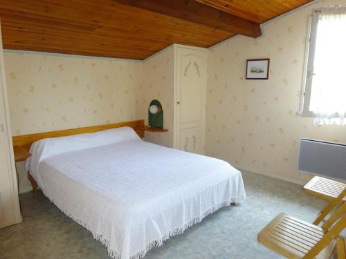 a bedroom with a white bed and a television at Les Lagagnons in Biscarrosse