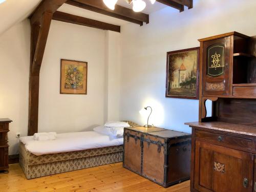 a bedroom with a bed and a chest in a room at The Houses of History - anno 1830 in Tihany