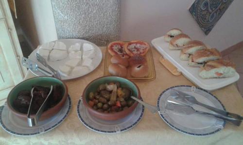 a table with plates and bowls of food and bread at Abbadia in San Vito lo Capo