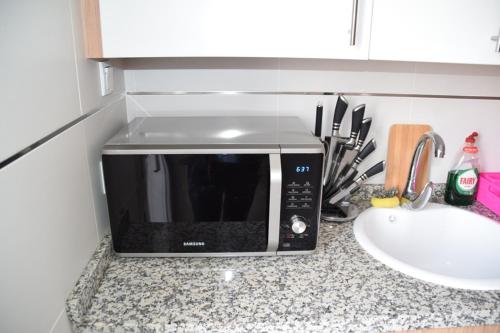 a microwave sitting on a counter next to a sink at Apartamento en sol, Ador in Ador