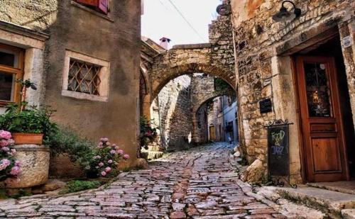an alley with an archway in an old building at Apartman Aleks in Bale