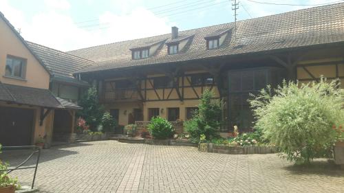 a large house with a brick driveway in front of it at Chez Frédéric et Alexandre in Bennwihr