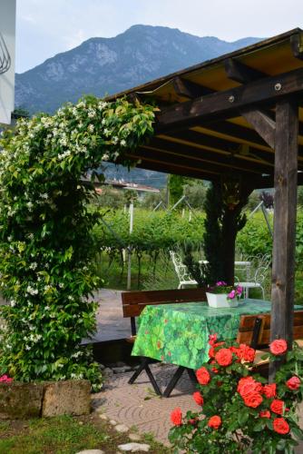 a table and a bench in a garden with flowers at La Casa nel Verde in Arco