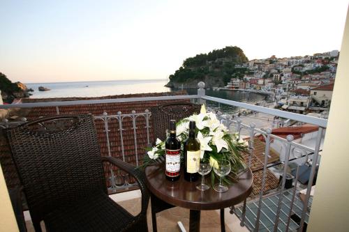 a table with wine bottles and flowers on a balcony at Acrothea Hotel in Parga