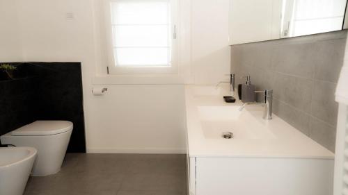 uma casa de banho branca com um WC e um lavatório em Ca' Belvedere em Sant'Elena di Silea
