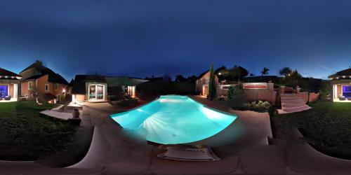 a swimming pool in a yard at night at LA BASTIDE DES 3 AS & Spa in Vriange