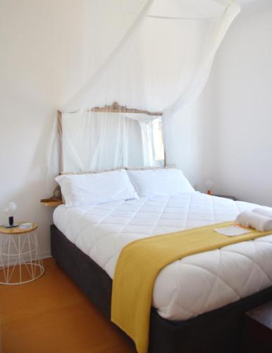 a bedroom with a large white bed with a yellow blanket at Lo spazio di Mima in Noto