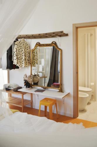a bedroom with a desk with a mirror and a bed at Lo spazio di Mima in Noto