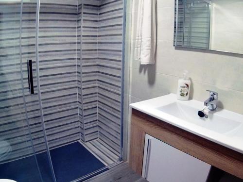 uma casa de banho com um chuveiro e um lavatório. em Apartamento Completo Maravall Centro em Benidorm
