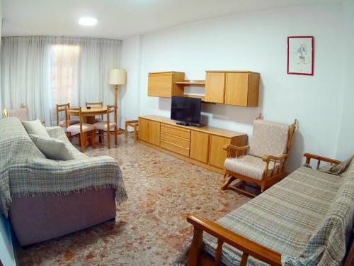 uma sala de estar com um sofá e cadeiras e uma televisão em Apartamento Completo Maravall Centro em Benidorm