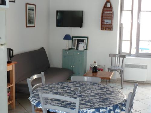un salon avec une table et un canapé dans l'établissement la maison de vincente, à Arzon