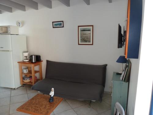 a living room with a couch and a table at la maison de vincente in Arzon