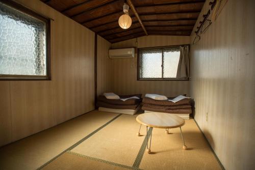 a room with a table and a group of beds at Air Osaka Hostel in Osaka