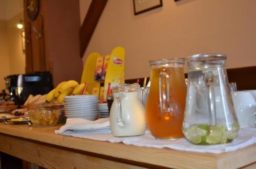 a table with two glass jars of juice and plates at Pension U Kohoutů in Horní Planá