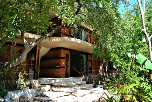 a house with a porch and stairs in front of it at Sunset House in Tulum