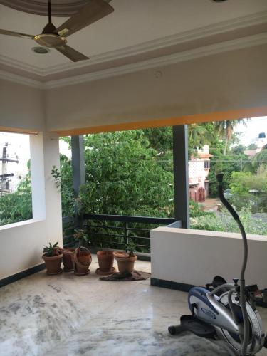 a room with a balcony with potted plants and a fan at Pleasant Stay in Tiruchchirāppalli