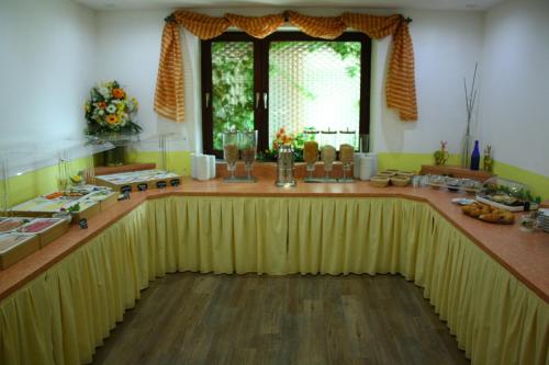 a kitchen with a large yellow table and a window at Hotel-Landgasthof Ploss in Schönwald