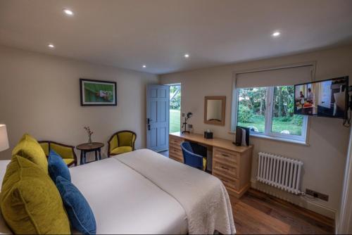 a bedroom with a bed and a desk and a window at The Broadmead Boutique B&B in Tenby