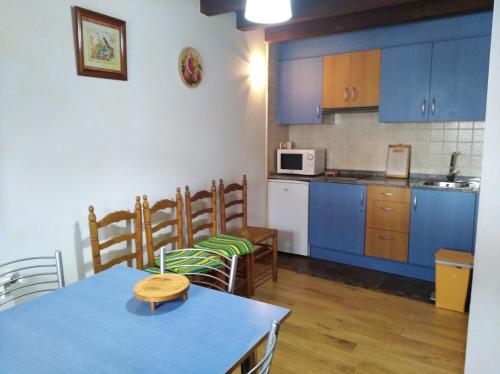 ArcediagoにあるCasa Souto De Abajoのキッチン(青いキャビネット、テーブル、椅子付)