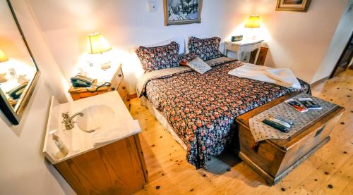 a small bedroom with a bed and a mirror at Auberge Baker in Chateau Richer
