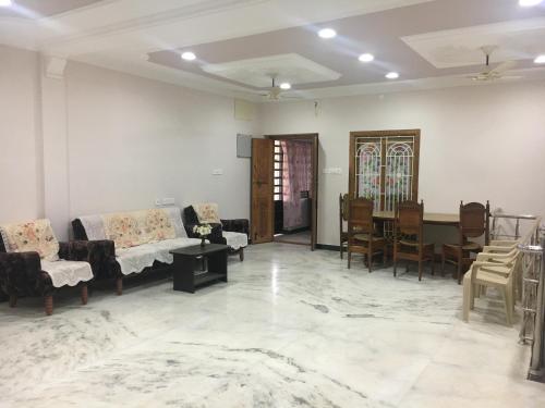 a living room with couches and a table and chairs at Pleasant Stay in Tiruchchirāppalli