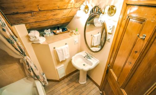 a bathroom with a sink and a mirror at Auberge Baker in Chateau Richer