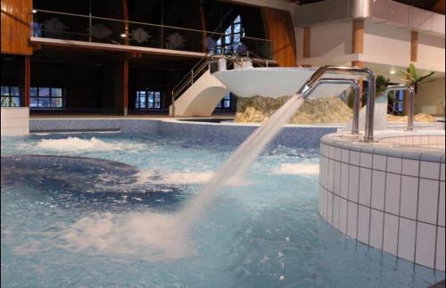 a water fountain in a swimming pool at Geri Apartman in Mezőkövesd