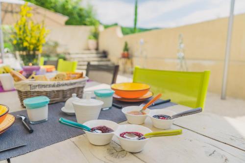 un tavolo con ciotole di cibo e utensili su di esso di Maison Sadina a Séguret