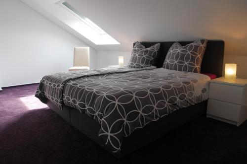 Schlafzimmer mit einem Bett mit einer schwarzen und weißen Bettdecke in der Unterkunft Kalles Heimat in Reichartshausen