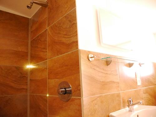 y baño con ducha, lavabo y espejo. en Villa Sperlingslust, en Rheinsberg