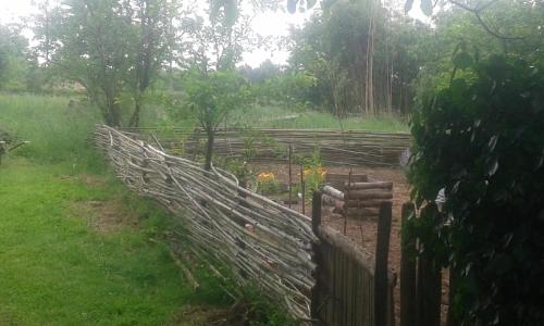 a fence in a field next to a garden at la vigneraie in Seigy