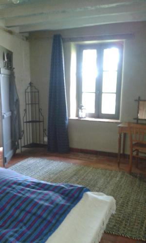 sypialnia z łóżkiem i oknem w obiekcie la vigneraie w mieście Seigy