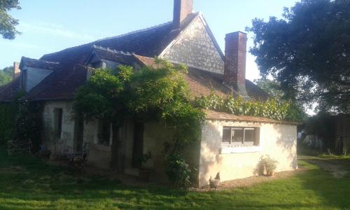 a small white house with ivy growing on it at la vigneraie in Seigy