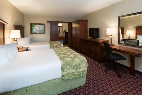 a hotel room with two beds and a desk at Rosen Inn International Near The Parks in Orlando