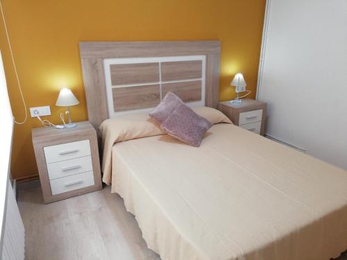 una camera con un grande letto e due comodini di Luminoso Apartamento Con Parking a Santiago de Compostela