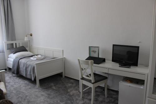 a bedroom with a bed and a desk with a computer at Hotel Amadeus in České Budějovice
