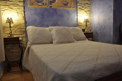 レトゥルにあるCasa Rural El Pajar del Portalicoのベッドルーム1室(白いベッド1台、ナイトスタンド2台付)
