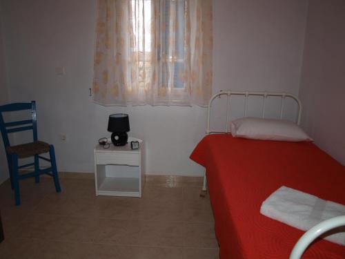a bedroom with a bed and a chair and a window at Alatsaria House in Cherronisos