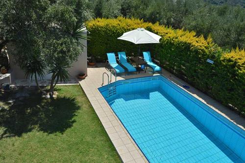 uma vista sobre uma piscina com cadeiras e um guarda-sol em Villa SteMa em Xirokámbion