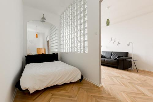 una camera bianca con un letto e un divano di Pamka place a Budapest