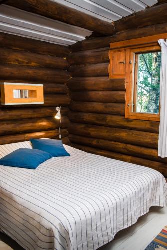 a bedroom with a bed in a log cabin at Koivulan Kartano Cottage in Lohja