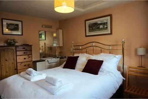 a bedroom with a large white bed with towels on it at Vale Cottage in Middleham