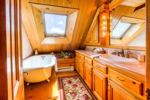 a bathroom with a tub and a sink at Auberge Baker in Chateau Richer