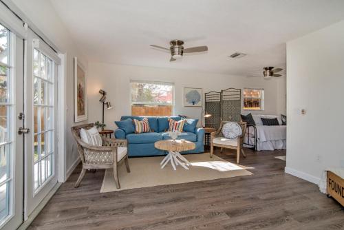 uma sala de estar com um sofá azul e cadeiras em Seaside Cottage B em Clearwater Beach