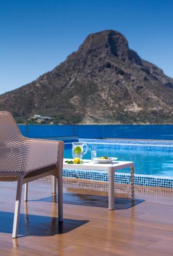 a table and a chair on a deck with a mountain at Carian Hotel in Masouri