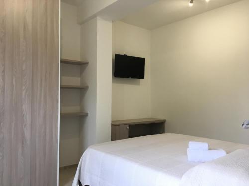 a bedroom with a bed and a tv on the wall at B&B Somiar in San Teodoro