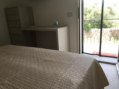 a bedroom with a bed and a large window at B&B Somiar in San Teodoro